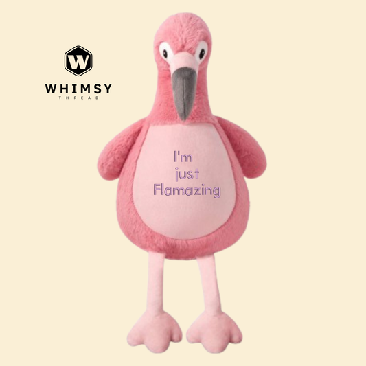 Pink flamingo plush toy with 'I'm just Flamazing' text on a beige background, branded with Whimsy Thread.